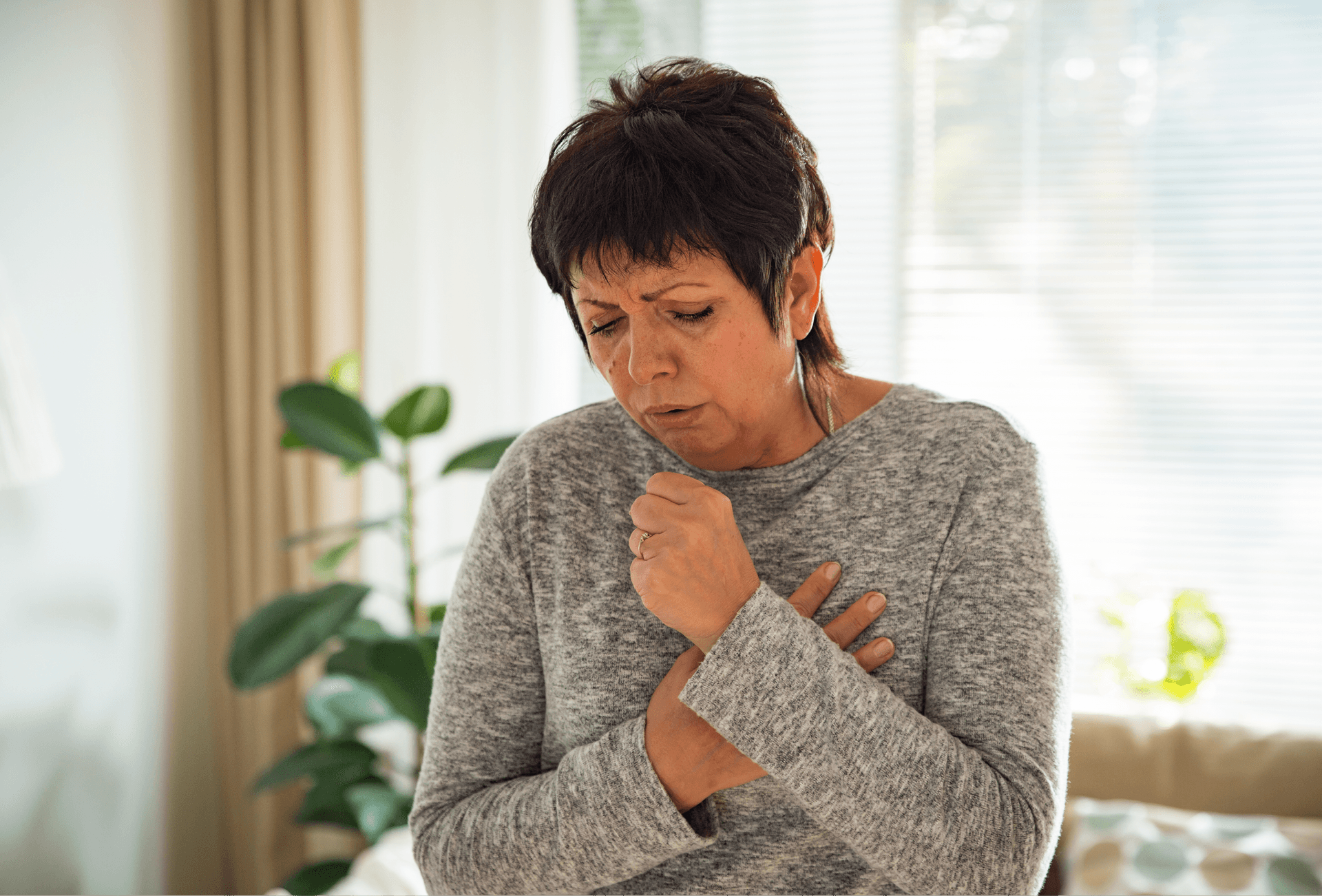 lady coughing and holding chest