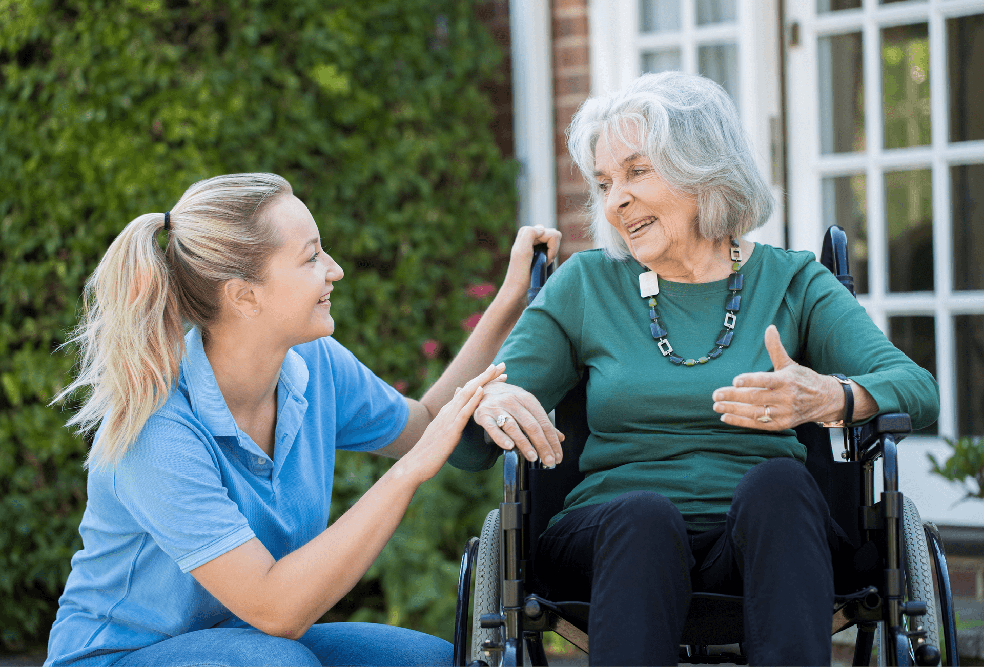 care home worker with elderly lady in wheelchair