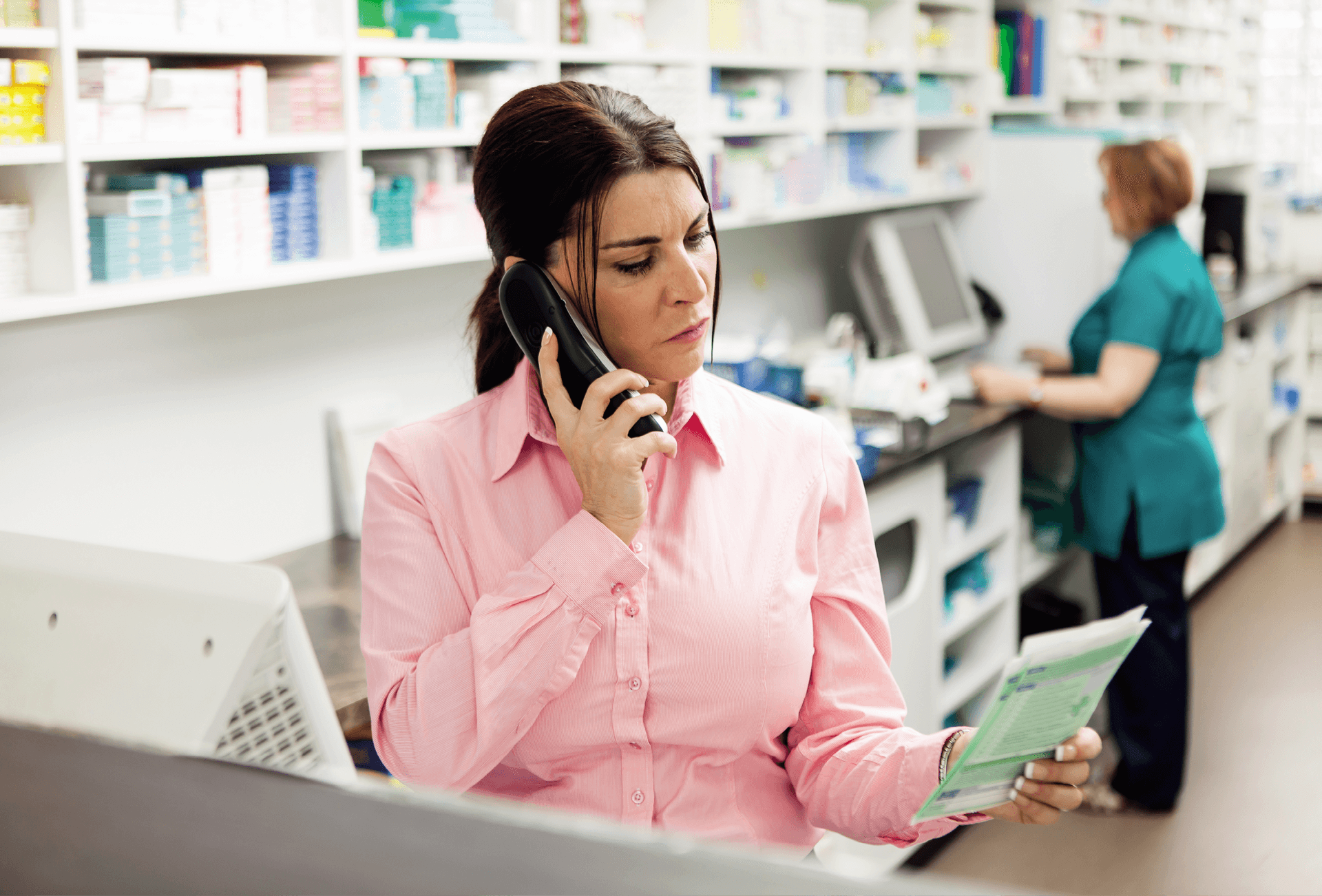 pharmacist looking at prescription whilst on phone