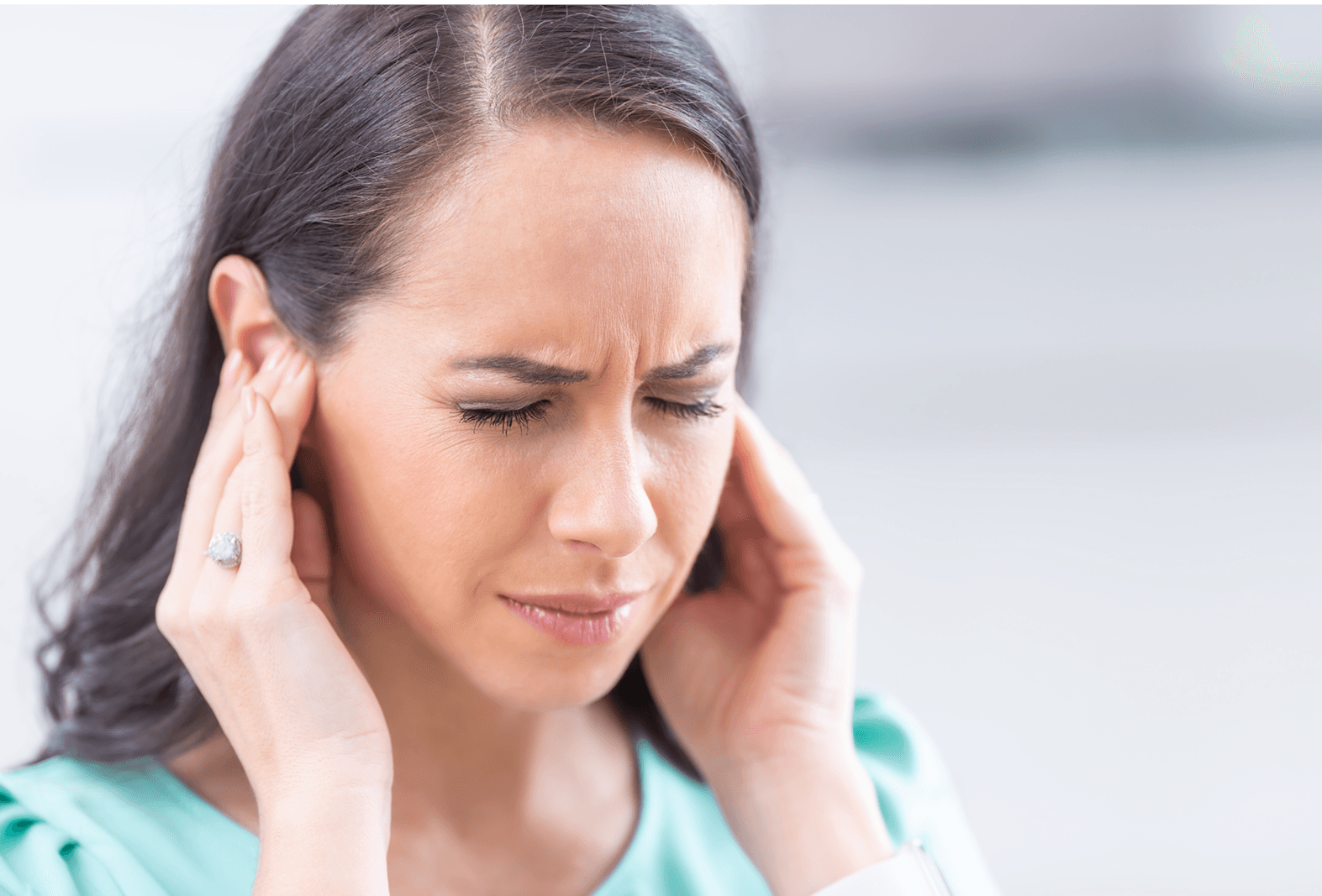 lady holding both ears in pain 