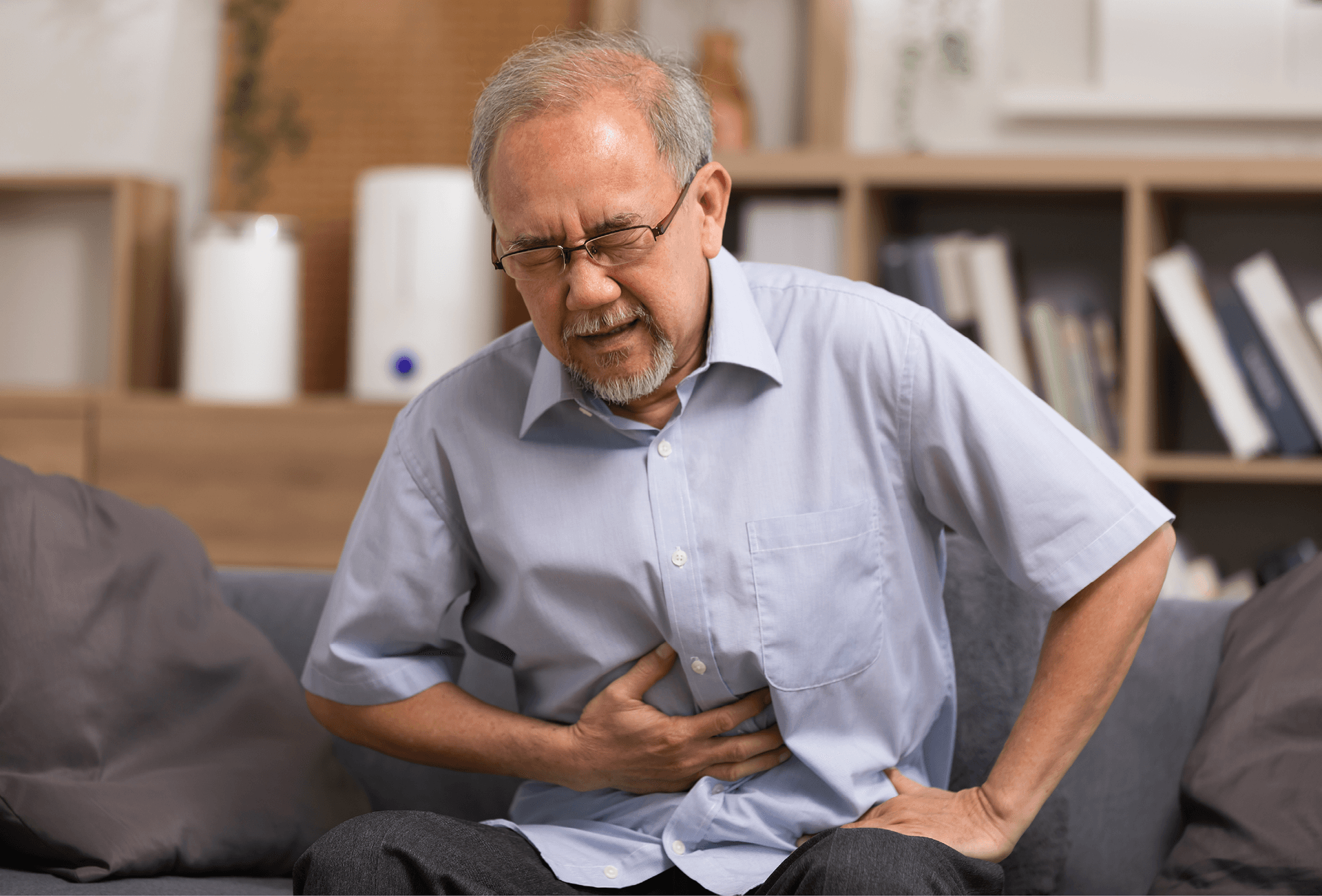 man rubbing stomach slightly bent over