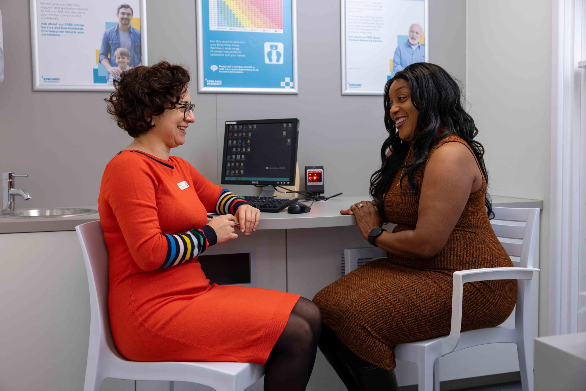 A female pharmacist talking with a female patient in a private consultation room