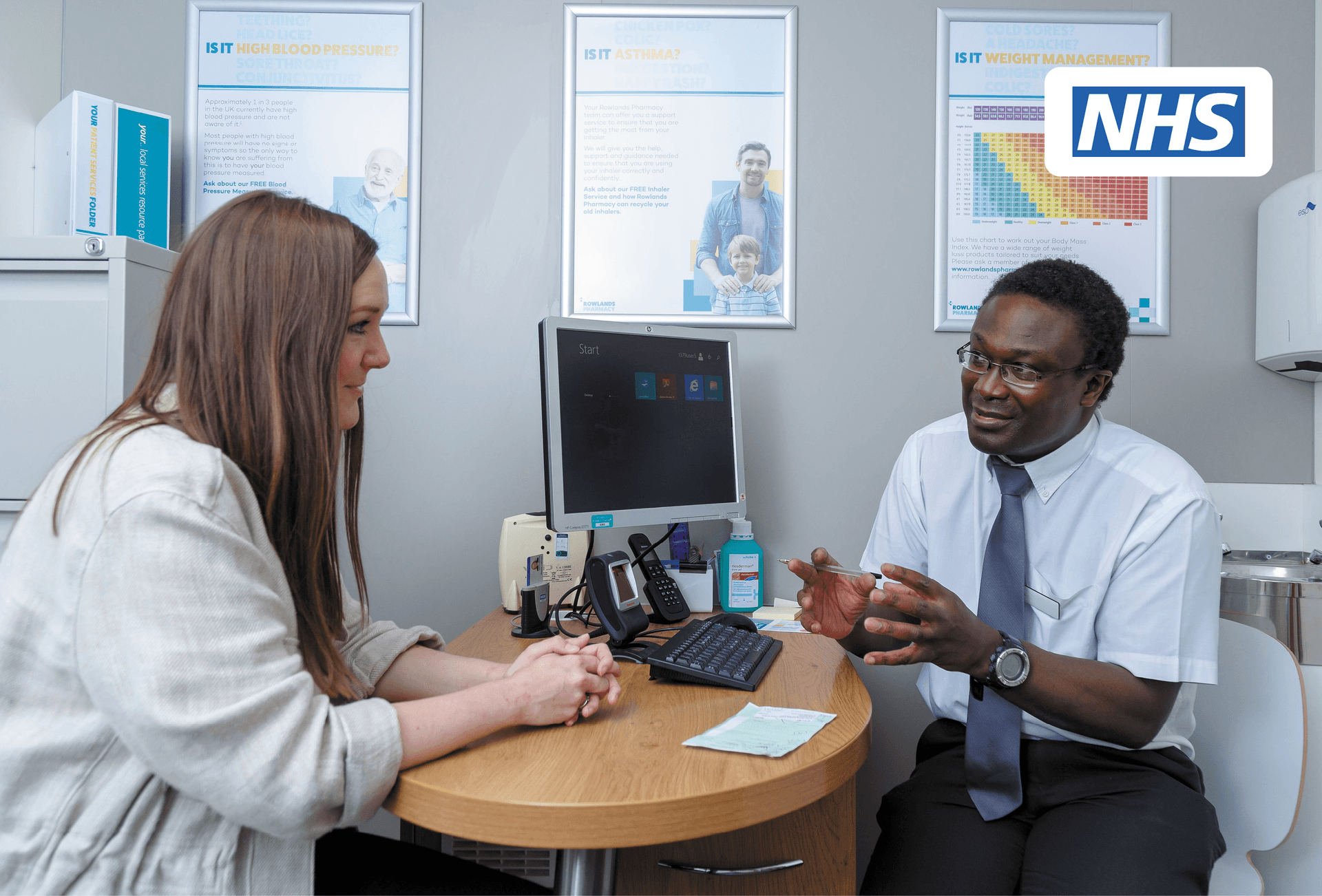 pharmacist giving advice to customer with NHS England logo