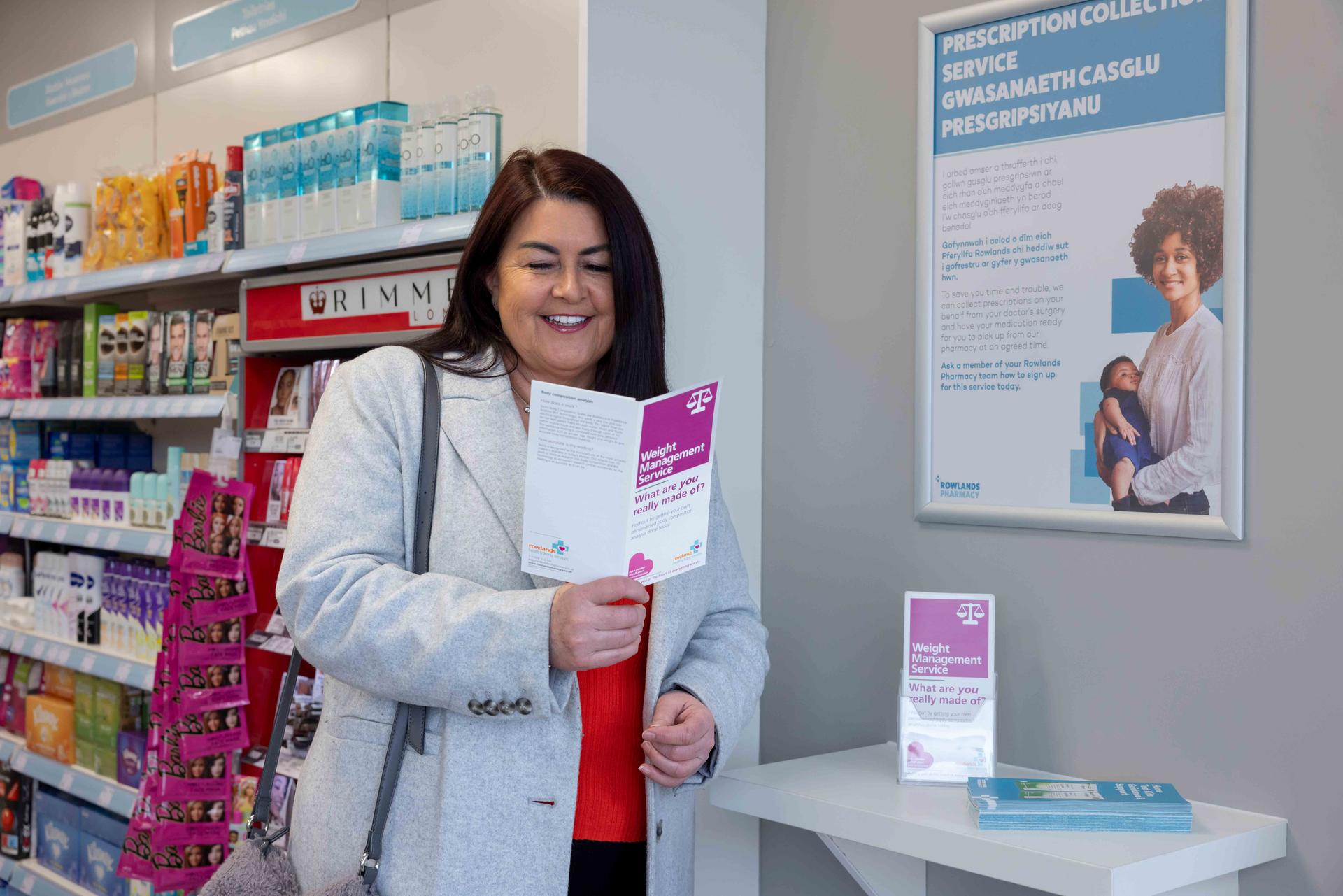 Lady reading a weight management leaflet at a Rowlands Pharmacy