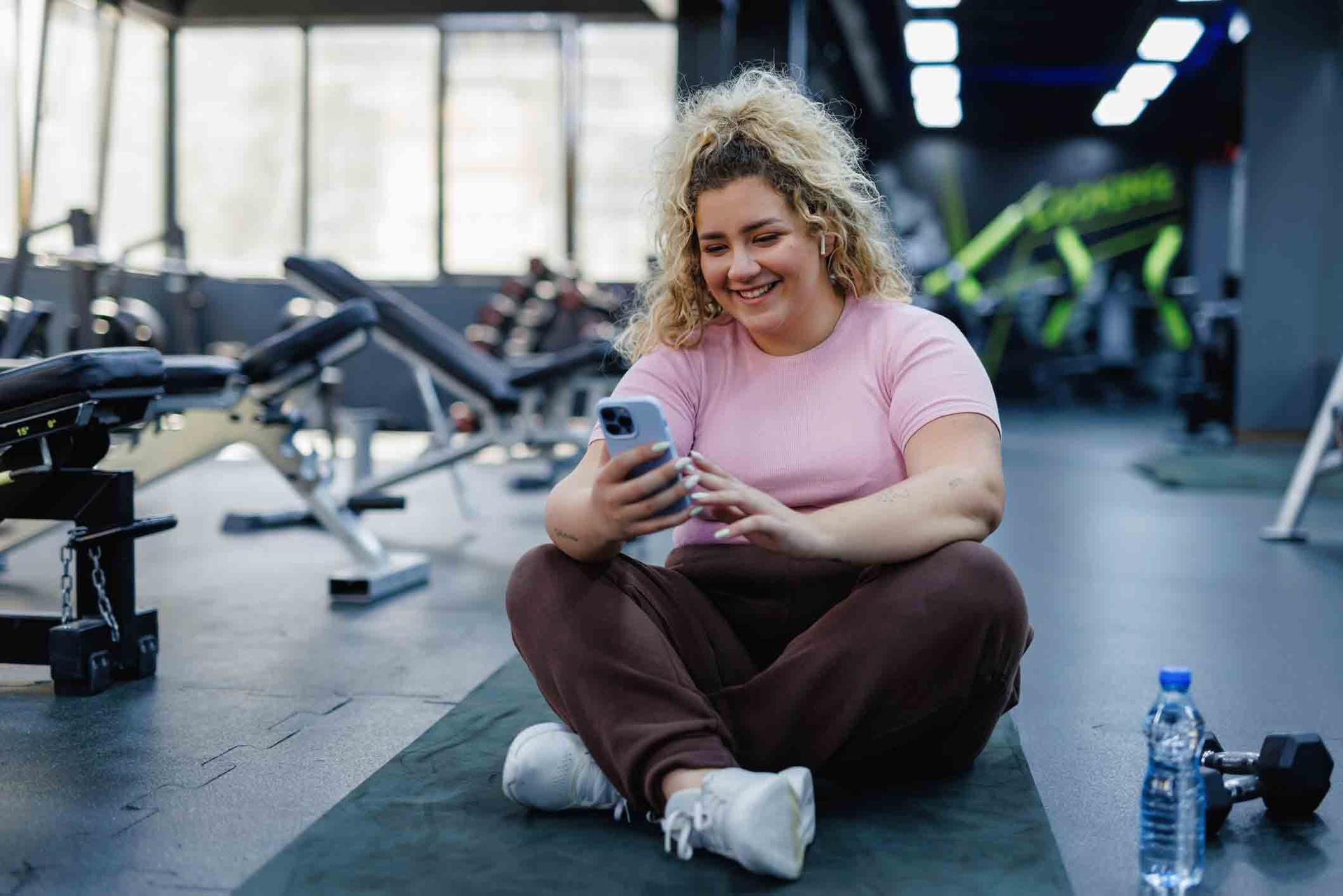 Lady checking her phone after a workout