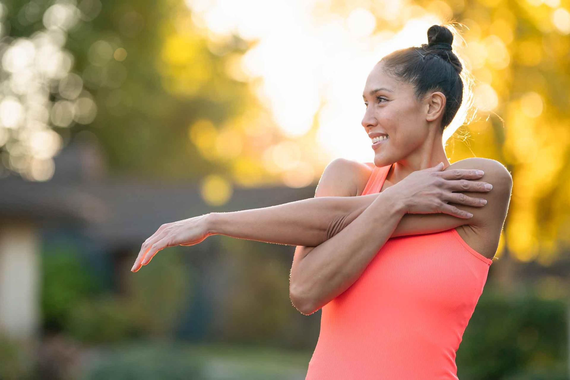 Healthy woman in workout gear stretching before exercising