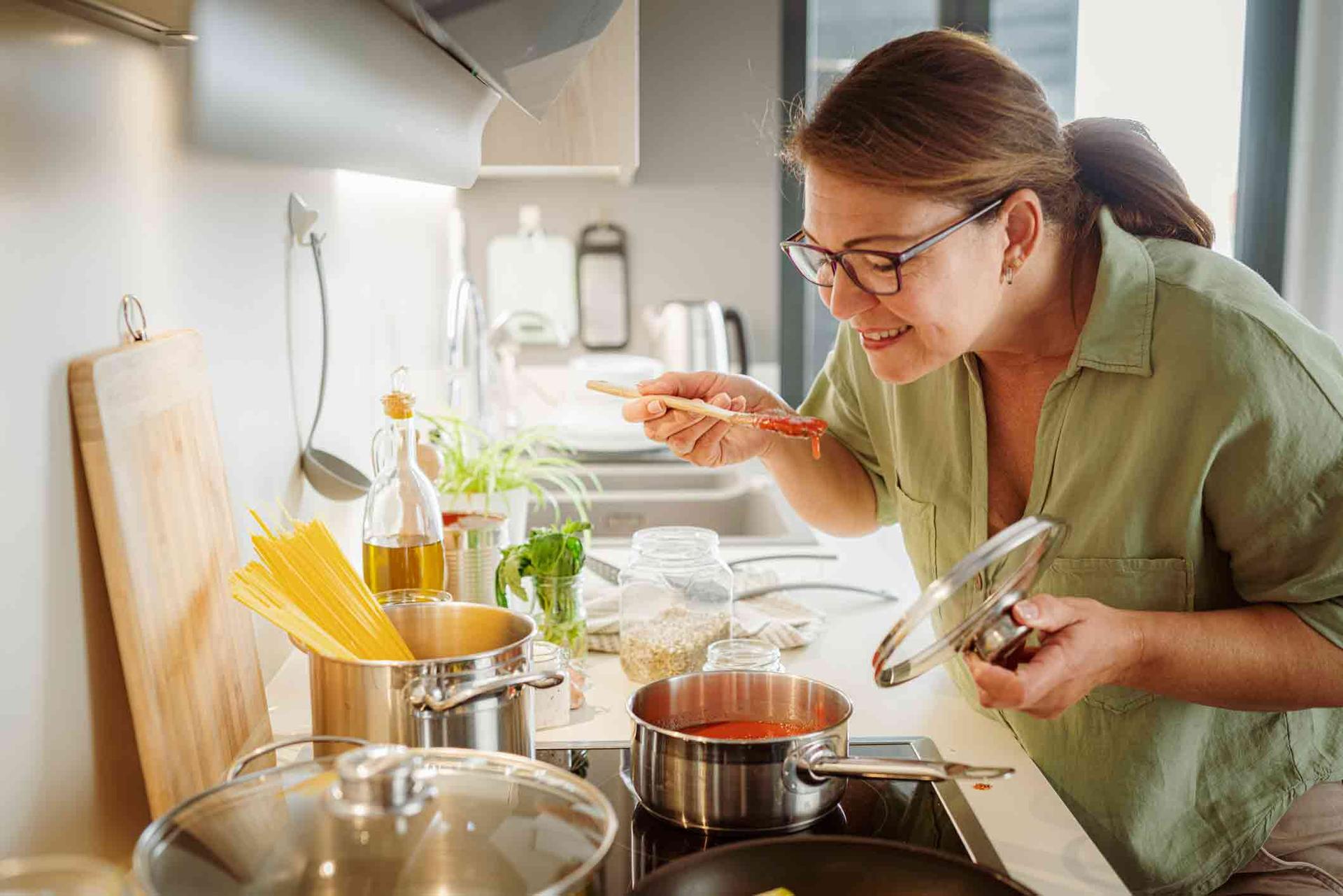 Woman making dinner and smelling the sauce