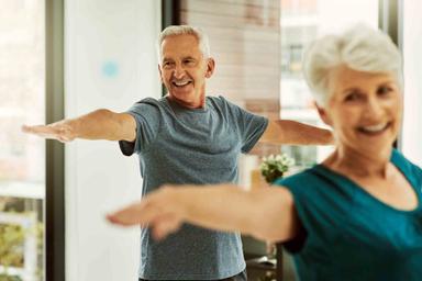 Senior man and woman doing yoga exercises together