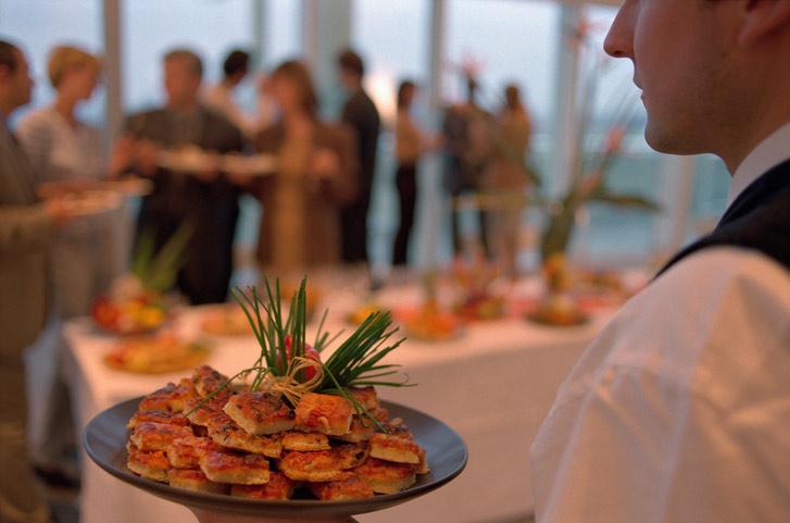 A waiter carrying party food at a social event