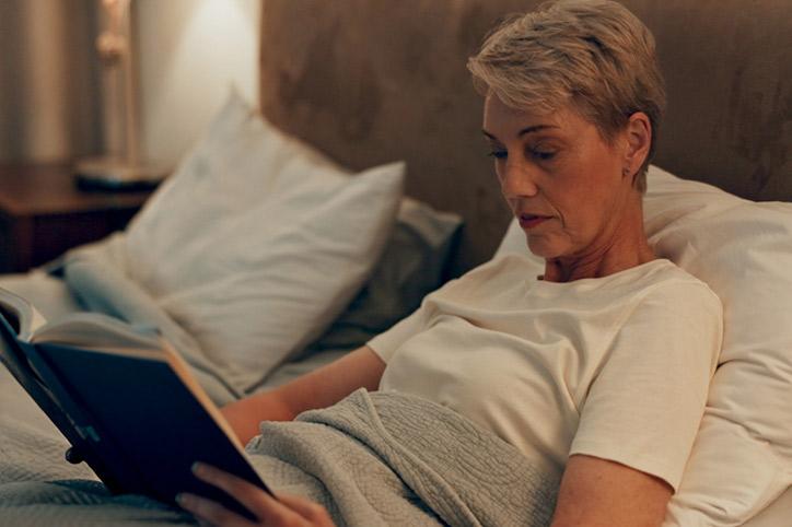 Lady reading a book in bed