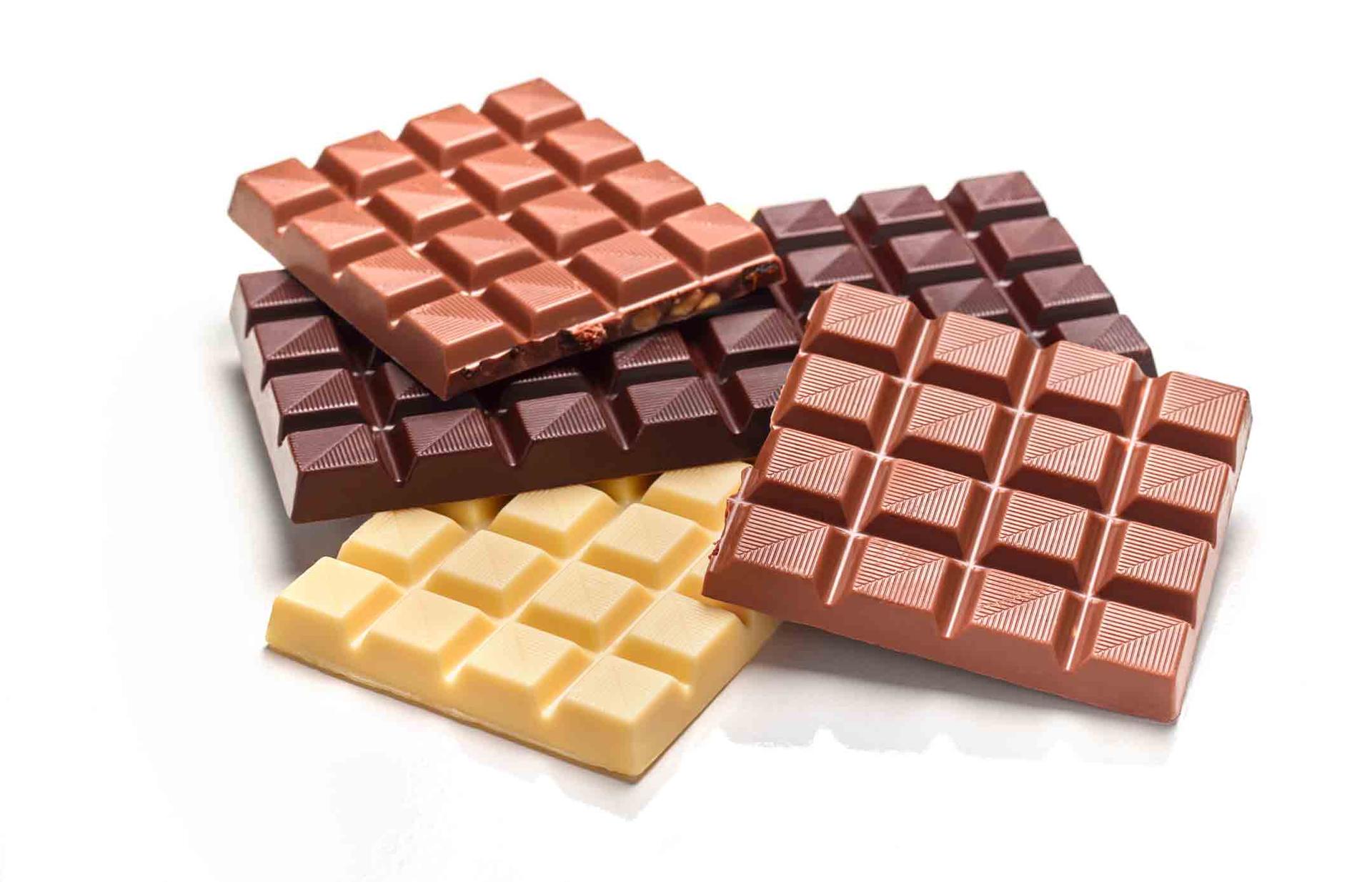 Four bas of white, milk, and dark chocolate stacked on top of each other.